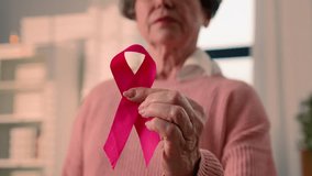 Old senior ill sick woman retired pensioner mature female lady hold red ribbon HIV AIDS awareness disease prevention sign volunteering charity symbol world breast cancer day volunteer oncology support - Powered by Shutterstock - Get 15% off with code: PIKWIZARD15