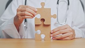 Doctor hand connecting couple puzzle piece, wooden jigsaw in hospital. Teamwork, Idea, Solution, challenge, success, Health, Medical and strategy concepts - Powered by Shutterstock - Get 15% off with code: PIKWIZARD15