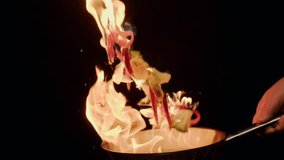 Flying vegetables on fire while cooking in frying pan. Chef prepares stew of broccoli, pepper, corn for side dish. - Powered by Shutterstock - Get 15% off with code: PIKWIZARD15