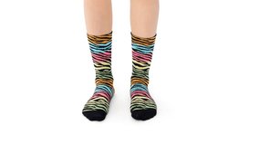 Colorful zebra print socks. The female model dances to the rhythm of the music. Twist dance. White endless studio. E-commerce and catalog videos. Isolated for promotion and advertising.