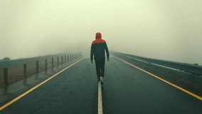 A man walking into the fog on the line of a lonely street with a hood - Powered by Shutterstock - Get 15% off with code: PIKWIZARD15