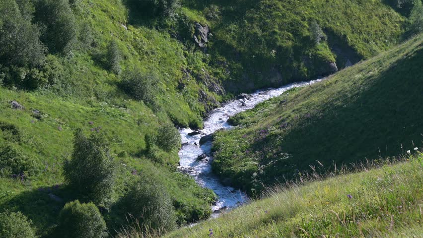 4k Video of water stream or river down the canyon originating from the melting snow at Mountains of Juta