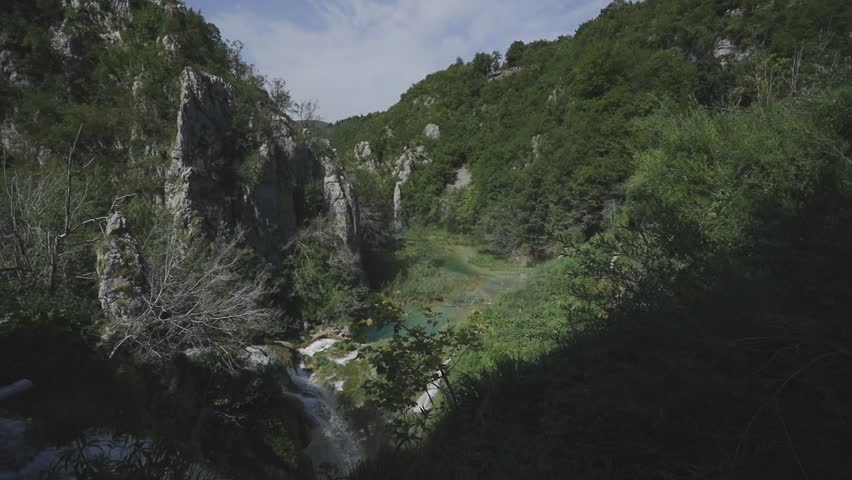 Panorama of Plitvice lakes in Croatia in summer. Wooden walkways over the crystal clear lakes transport us to an idyllic naturalistic landscape. An adventure between waterfalls, rivers and lakes.