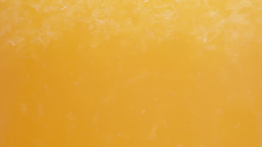 Orange juice with pulp, macro textures in a glass.