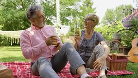 Elderly couple picnicking in the garden