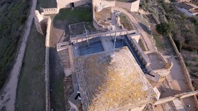 Panoramic aerial drone view of old medieval tower and castle wall of old Benabarre castle and view of surrounding area, perfect example of beautifully landscaped ancient architecture. Aragon,Spain.4K