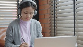 Young asian student woman using video conference call on laptop during remote online class, studying using laptop