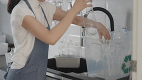 Net Zero waste go green eco people save the planet earth wash rinse clean empty reuse glass bottles sort before recycle bin on touchless sensor faucet tap sink smart home. World water day plastic free - Powered by Shutterstock - Get 15% off with code: PIKWIZARD15