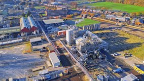 Aerial footage moving towards a large industrial chemical plant, showing pipelines, metal structures, cooling towers and chemical storage. UK