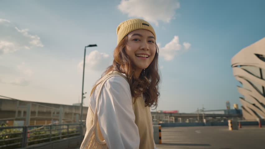 Young Gen Z girl asia people curly brown hair, face, eye smile in blue sky sun light lens flare. Teen urban city life happy joy of future hope enjoy warm time relax sunset. Good mental health teenage. Royalty-Free Stock Footage #1107675907