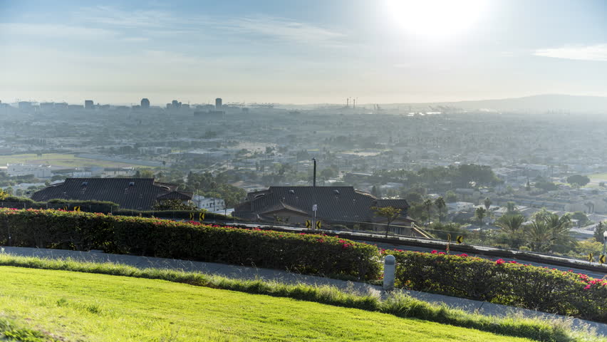 A view of Signal Hill in Long Beach California from daytime into night shows the city come alive with lighted color.