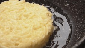 Close-up panorama of the fried potato pancake on the frying pan. Potato pancakes draniki recipe. High quality FullHD footage