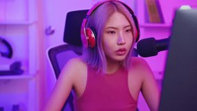 Asian beautiful Esport woman gamer play online video game on computer. Attractive young girl gaming loser player feeling frustrated and angry while broadcast live streaming playing cyber tournament.