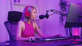 Asian beautiful Esport woman gamer play online video game on computer. Attractive young girl gaming loser player feeling frustrated and angry while broadcast live streaming playing cyber tournament.