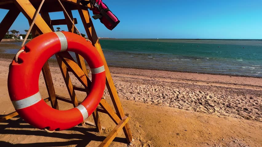 Guardians of Safety: Lifebuoy in Lifeguard's Tower. High quality 4k footage. Ensuring safety along the shore, a lifebuoy stands ready in a lifeguard's tower. This image symbolizes the dedicated Royalty-Free Stock Footage #1107684645