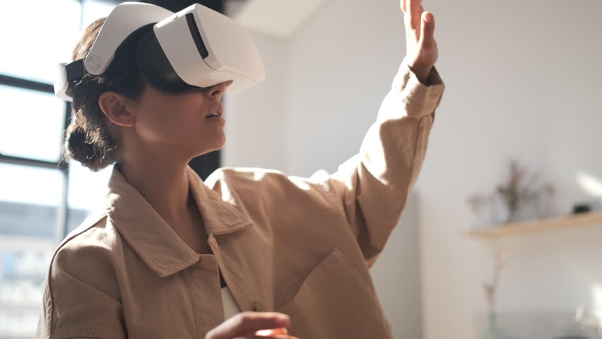 Beautiful young female playing game in vr glasses. Happy woman touch something using modern virtual reality glasses. Augmented Reality. Student playing using VR glasses on a sunny day. Slow motion  Royalty-Free Stock Footage #1107687949