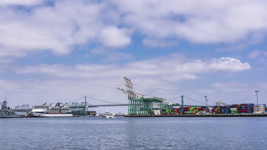 A tugboat motors across ports of call in Long Beach California in route to escort a freighter to the loading docks.