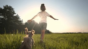 girl running with dog on the grass in the park. happy family childhood dream concept. the dog runs next to the little girl. child and his pet have fun together in the park lifestyle on the grass - Powered by Shutterstock - Get 15% off with code: PIKWIZARD15