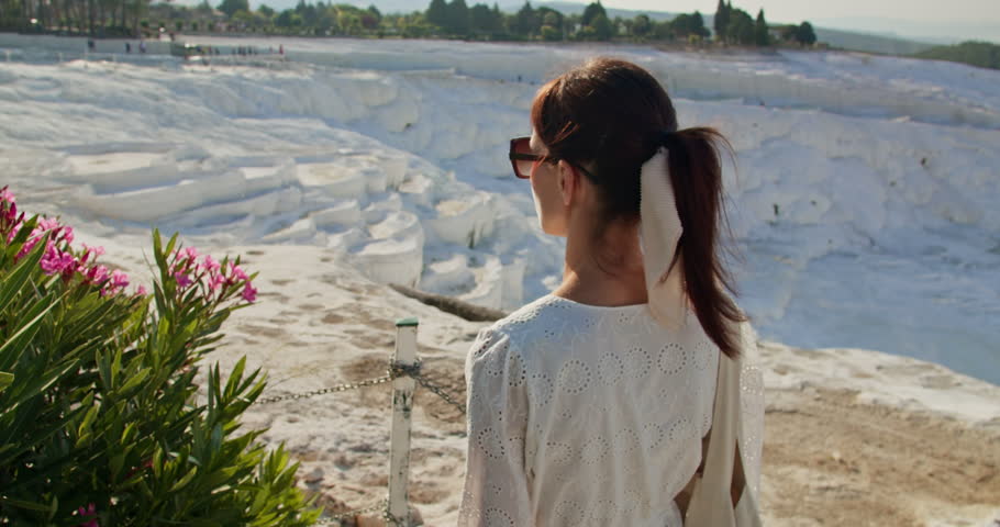 Woman enjoying view of travertine pools limestone terraces in Pamukkale, Turkey travel