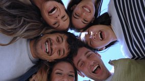 Multiracial group of young beautiful people standing in circle and smiling excited at camera. Happy diverse generation z friends having fun embracing together. Low angle view sunny portrait outdoor. - Powered by Shutterstock - Get 15% off with code: PIKWIZARD15