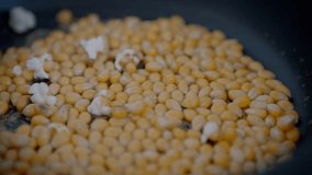 Slowmotion of homemade popcorn popping wildly from a frypan. Crunchy pop corn snack in cooked a pan. delicious and tasty corns kernels almost popped with salt - Powered by Shutterstock - Get 15% off with code: PIKWIZARD15