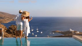 A hugging, loving couple on vacation time enjoys the summer sunset over the Aegean Sea by the swimming pool with a drink - Powered by Shutterstock - Get 15% off with code: PIKWIZARD15