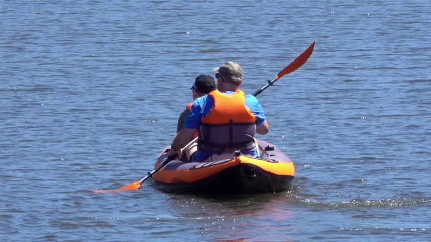 Zooming out from two people canoeing on the River Medway in June at Allington Lock, near Maidstone, Kent, England, UK.