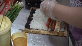 A Korean woman makes sushi in her restaurant kitchen. Learn the process in this step-by-step video in a proper sanitation