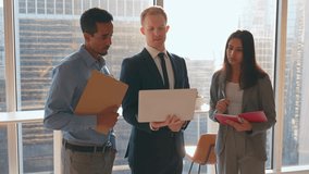 Diverse work team people looking at laptop computer discussing digital financial trading or marketing strategy. Male corporate leader showing online project results to coworkers standing in office. - Powered by Shutterstock - Get 15% off with code: PIKWIZARD15
