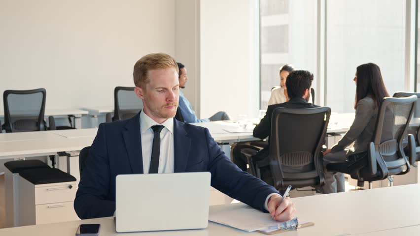 Busy business man manager employee wearing suit using laptop in company office. Young male digital professional worker executive using computer technology watching webinar elearning sitting at desk. Royalty-Free Stock Footage #1107713977