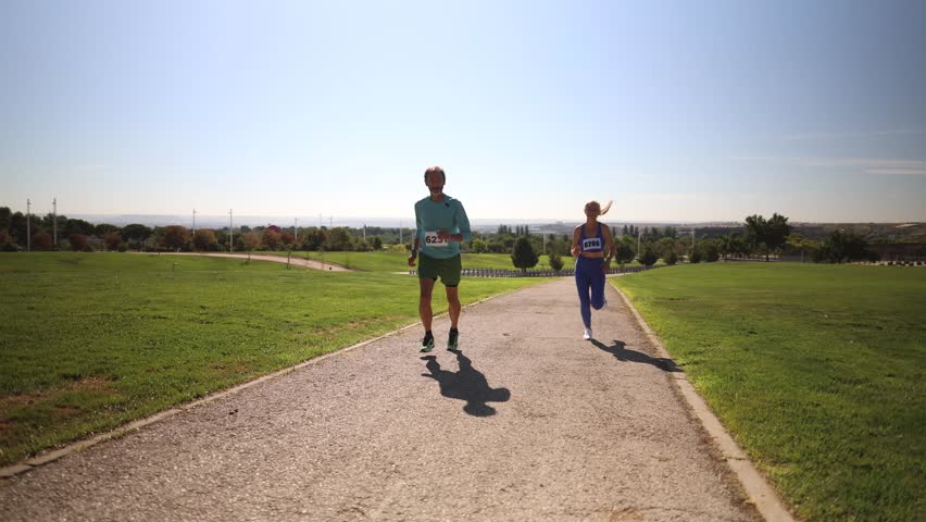 high level runners in a marathon - people who compete in fitness and healthy active lifestyle on the road. mature couple running a race