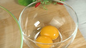 Chef puts separate whole egg yolk into glass bowl close up. Food video, promotion, marketing, restaurante. Preparing desserts at home