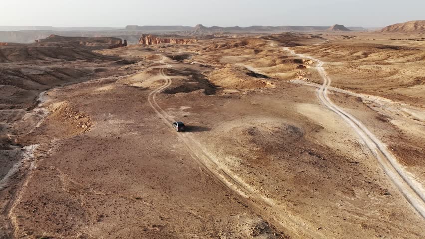 The drone is flying forward following a car driving towards the edge of the world in Riyad Saudi Arabia Aerial Footage 4K