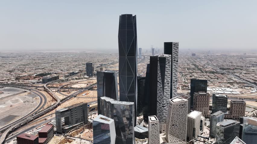 The drone is flying around the skyscrapers of the King Abdullah Financial District to the top in Riyad Saudi Arabia Aerial Footage 4K Royalty-Free Stock Footage #1107724401