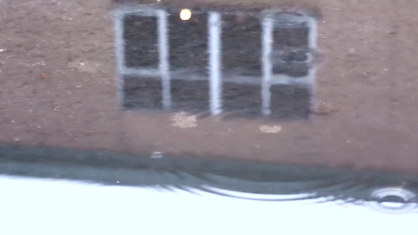 Rain drops with house relfection on the water surface 