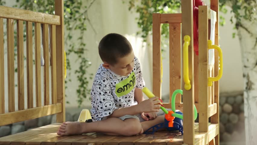 A teenager sits on the playground and launches an air rocket