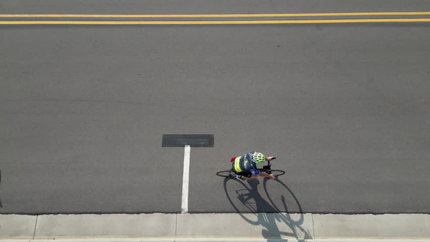 Slow motion moving aerial perspective of bicyclists enjoying a ride together on a sunny day.