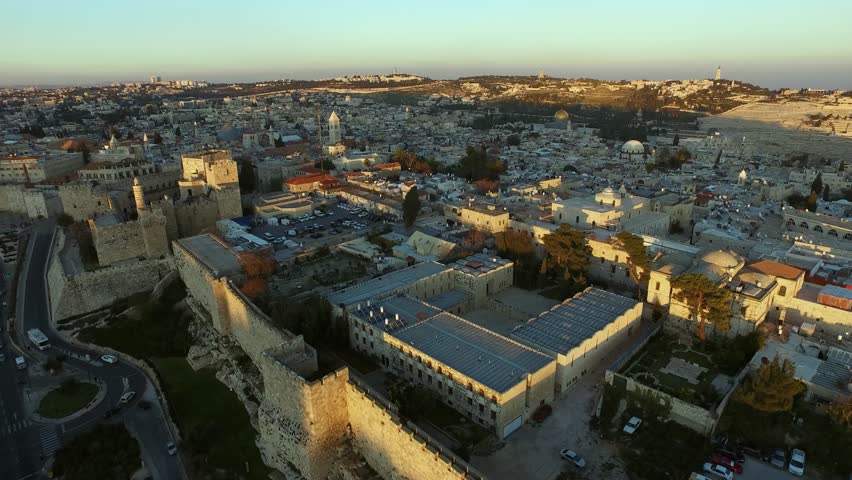 Jerusalem from above, you can see the old city, the Tower of David, the Dome of the Rock, the tracks along which cars drive. Shade on the buildings. Summer, spring. Aerial photography. 4K
