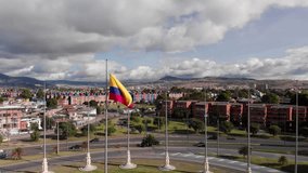 Colombian flag in the background you can see the city of Bogota, with a background road with traffic and horizontal grass, plane