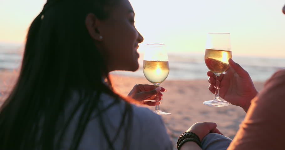 Sunset, beach and couple toast with wine for love, relax or celebrate anniversary from the back. Happy man, woman and cheers at sea with alcohol, champagne or drink for celebration, vacation or party Royalty-Free Stock Footage #1107737761