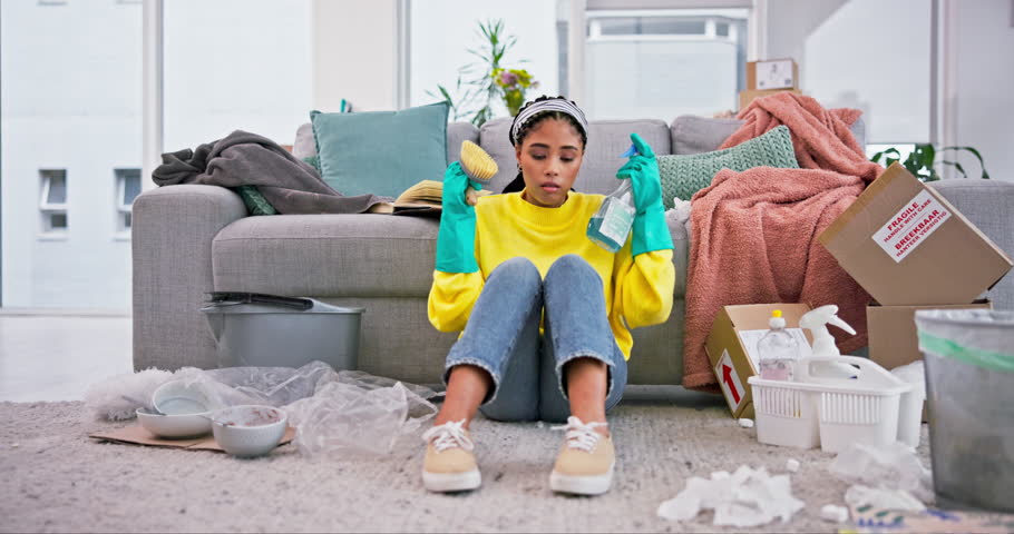 Cleaning, sad and woman in living room with depression and tired from messy home of cleaner. Burnout, fatigue and female person with spray, brush and washing task fail and frustrated in a house Royalty-Free Stock Footage #1107738075