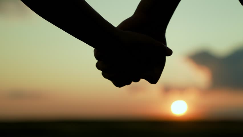 Closeup of guy lets go of girls hand, separation. Separation of hands of man of woman. Family at sunset. Pair of man, woman separate their hands in front of sun. Separation, separation, quarrel. Royalty-Free Stock Footage #1107739179