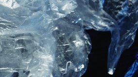 Vertical video. Plastic collection. Zero waste. Garbage management. Used wet polyethylene bags in wind crushed bottles rubbish dump on dark blue background.