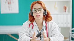 Young redhead woman doctor on video call at clinic