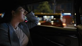 Business Chinese woman driving in a taxi at night. Shot with RED helium camera in 8K. 