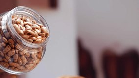 A jar of peanuts falling from above, being poured into another jar - Powered by Shutterstock - Get 15% off with code: PIKWIZARD15