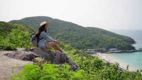 Asian woman traveler using mobile phone taking selfie at tropical island mountain peak in sunny day. Attractive girl enjoy and fun outdoor lifestyle travel nature ocean in summer holiday vacation trip