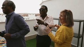 rooftop party of multiracial senior people drinking and dancing - Powered by Shutterstock - Get 15% off with code: PIKWIZARD15