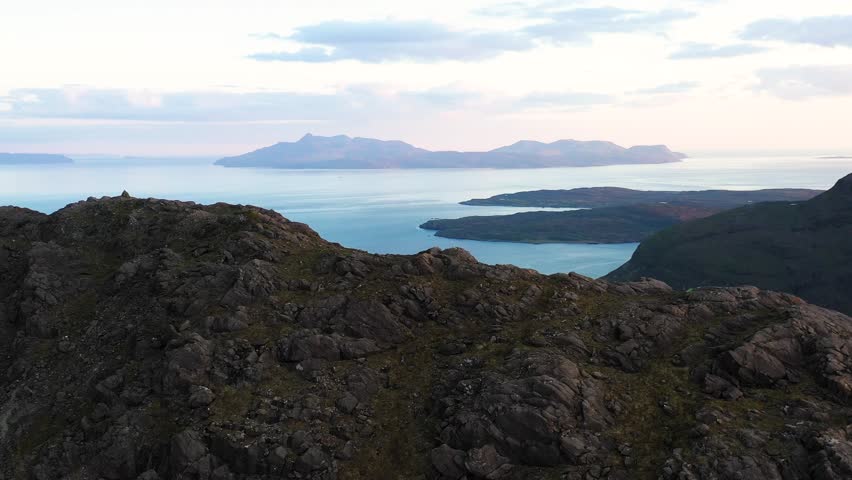 Aerial view of the Jagged Mountains, Lochs and Sea on the Isle of Skye, Scotland UK at Sunset with Colourful Skies. Hiking and camping in the Cuillin Mountains. 