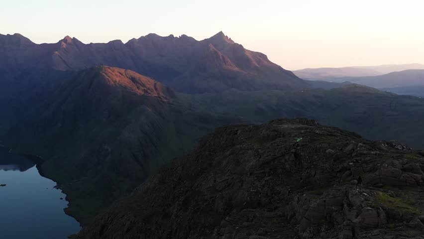 Aerial view of the Jagged Mountains, Lochs and Sea on the Isle of Skye, Scotland UK at Sunrise with colourful skies. Hiking and camping in the Cuillin Mountains. 